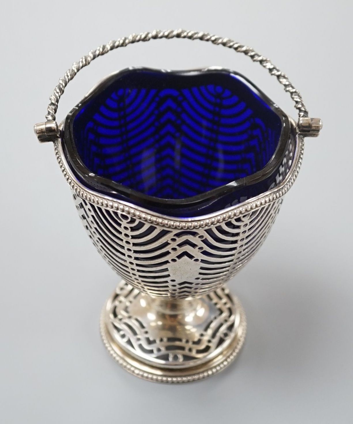 A George III pierced silver sugar basket, Burrage Davenport, London, 1777, with blue glass liner, height 96mm.